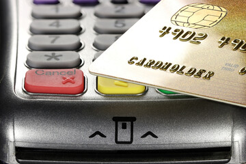 gold status bank or loyalty card held over payment terminal