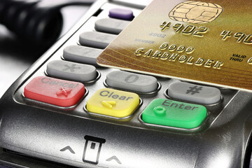 gold status bank or loyalty card held over payment terminal