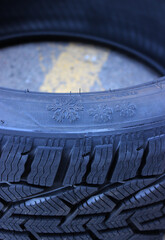 Tire tread blocks and snowflake icon on a sidewall of the new winter tire. Snow non studded tyre for hard weather condition