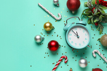 Composition with alarm clock, Christmas balls, candy cane and confetti on turquoise background. Christmas countdown concept. Top view