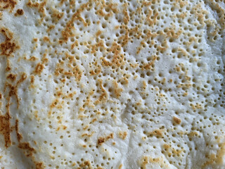 The porous surface of a fried thin pancake.