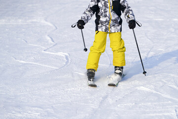 A child on skis on a snowy slope. Copy space.