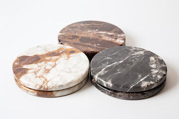 Naklejka premium Elegant marble coasters in various shades are beautifully arranged against a white background, perfect for adding style to any dining setting.
