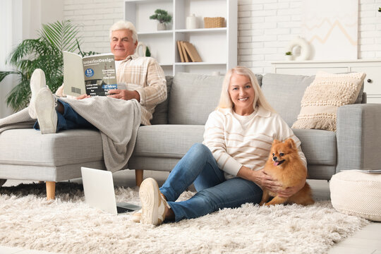 Happy senior couple with cute Pomeranian dog at home
