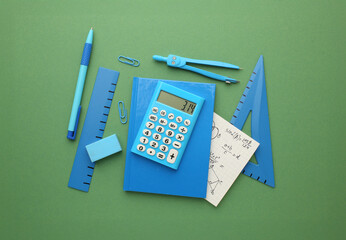 Stationery calculator ruler calculator and school cheat sheets on coloured background. Concept of school and college learning