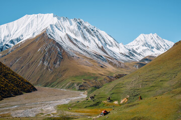 Sheperd's house and snow-capped mountains at the end of the Truso Gorge, near the South Ossetia border in Kazbegi region of Georgia