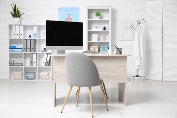 Interior of medical office with doctor's workplace and shelf units
