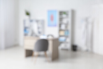 Blurred view of medical office with doctor's workplace and shelf units