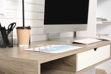 Eyeglasses with diagram on desk in office, closeup