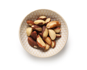 Bowl with tasty Brazil nuts on white background