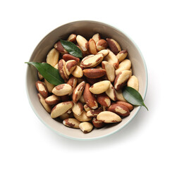 Bowl with tasty Brazil nuts and leaves on white background