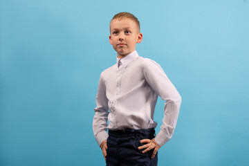 Child 8-9 years old on a blue background. Portrait of a boy with different facial expressions.