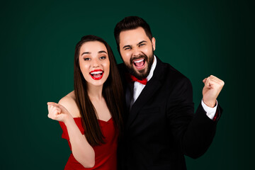 Photo of attractive young man woman couple winning raise fists dressed stylish fancy clothes isolated on green color background