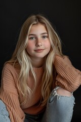 Young girl with long blonde hair sitting on a chair