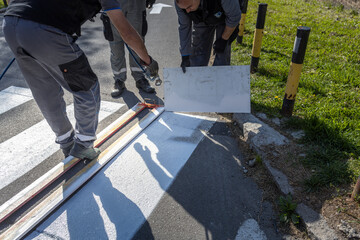 Man is painting a crosswalk with a spray can