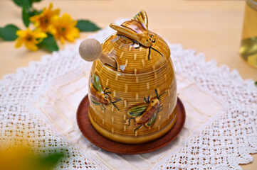 beautiful still life with a honey pot and yellow flowers on the table