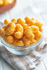Puffed crispy Peanut flips in bowl on white table.