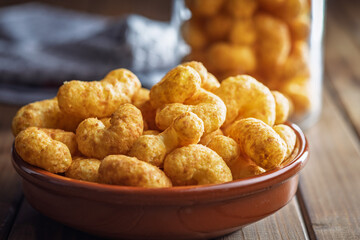 Puffed crispy Peanut flips in bowl on wooden table.