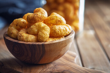 Puffed crispy Peanut flips in bowl on wooden table.