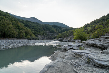 Osumi Gorge, Albania - August 15 2024: Stunning view of Osumi Canyon (Albanian: Kanioni i Osumit), showcasing the breathtaking cliffs, vibrant greenery, and winding river through dramatic landscape.