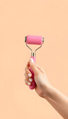 Pink Body roller massager in female hand on beige background, copy space. body care isolated with white highlights, png