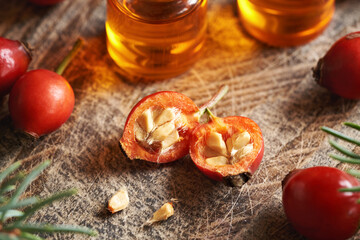 Rosehip berries with seeds with rose hip oil in the background