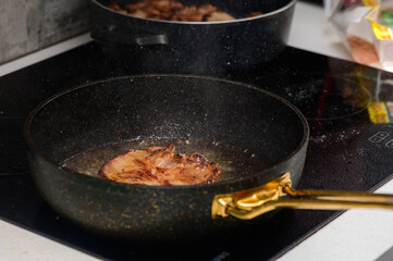 Cooking delicious pork chops in a sleek pan on a modern stovetop, creating savory aromas in the kitchen