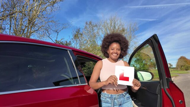 Hampshire England UK. 01.11.2024. Video.  Happy learner driver passes driving test and is seen here dancing for joy holding the L plate.