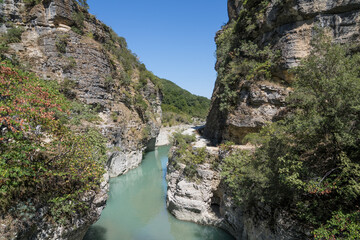 Osumi Gorge, Albania - August 15 2024: Stunning view of Osumi Canyon (Albanian: Kanioni i Osumit), showcasing the breathtaking cliffs, vibrant greenery, and winding river through dramatic landscape.