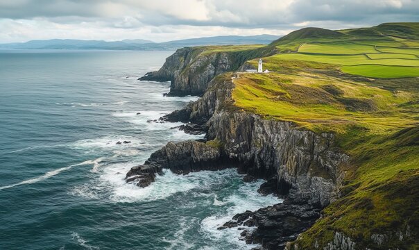 Sweeping aerial view of a coastal cliffside with waves crashing against the rocks, and a lighthouse standing tall on the edge.