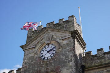 Obraz premium clock tower of stone building in UK town. Old English architecture.
