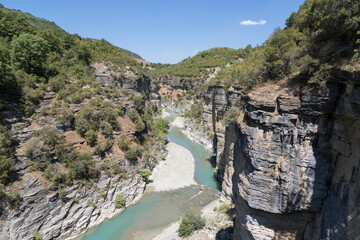 Osumi Gorge, Albania - August 15 2024: Stunning view of Osumi Canyon (Albanian: Kanioni i Osumit), showcasing the breathtaking cliffs, vibrant greenery, and winding river through dramatic landscape.