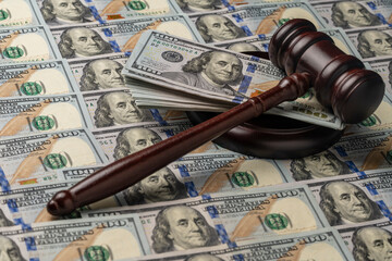 Wooden judge gavel, soundboard with US 100 dollar bills on the background, closeup. Finance and justice concept