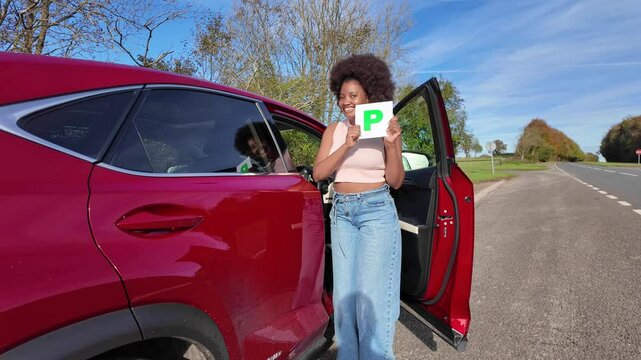 Hampshire England UK. 01.11.2024. Video. Probationary driver just passed her test holding a green P Plate and dances with joy.