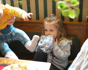 child wipes face after meal, family
