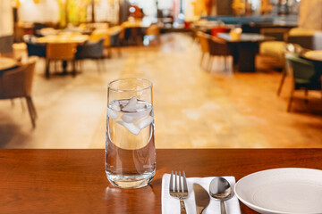 Glass of water on restaurant table. Clean drinking water, water conservation and restrictions concept.