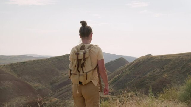 Woman tourist using paper map travels in mountains.
