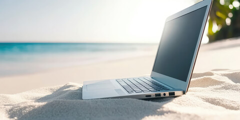 Laptop lies on the sand of a sunny tropical beach, copy space. Creative concept of remote work, freelancing
