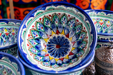 Colorful ceramic tableware with oriental ornaments close-up.