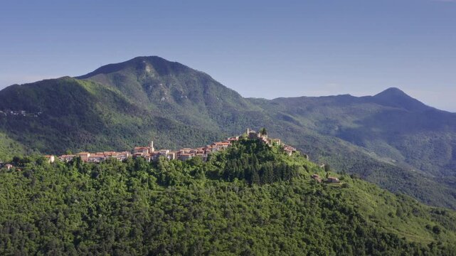 Mountain Village Chuch in Liguria: Drone View of Italy&rsquo;s Green Hills and Mountain Panorama on a Bright Day with Blue Sky &ndash; Wide Shot Drone Flyover Tracking Right