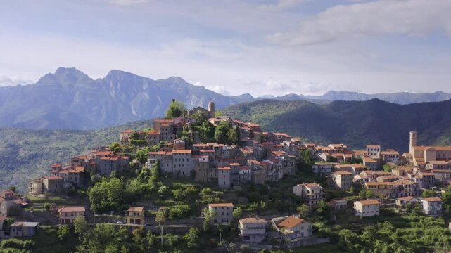 Mountain Village in Liguria: Drone View of Italy&rsquo;s Green Hills and Mountain Panorama on a Bright Day with Blue Sky &ndash; Slow Drone Flyover Tracking Right