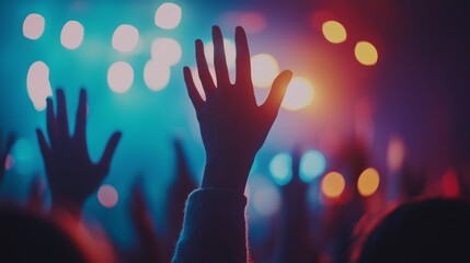 Vibrant concert crowd with raised hands and colorful lights