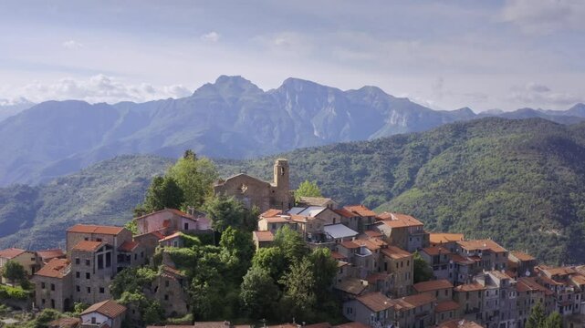 Mountain Village in Liguria: Drone View of Italy&rsquo;s Green Hills and Mountain Panorama on a Bright Day with Blue Sky &ndash; Drone Flyover Tracking Right