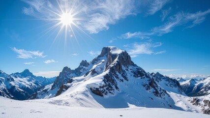 "Sunlit Snow-Capped Mountain Range Under a Clear Blue Sky"
