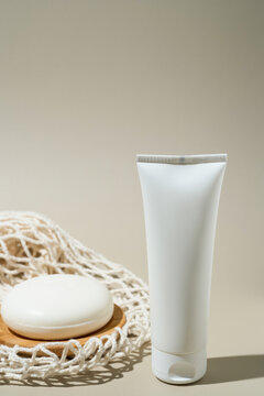 Hand cream tube with soap on neutral backdrop