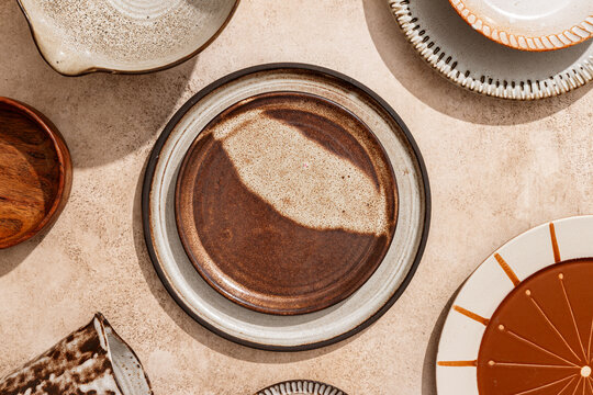 Top view of assorted ceramic tableware on textured surface