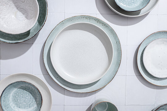 Top view of artisan ceramic pottery dishes on tiled surface