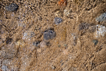 Texture of sand and stones on the beach close-up.