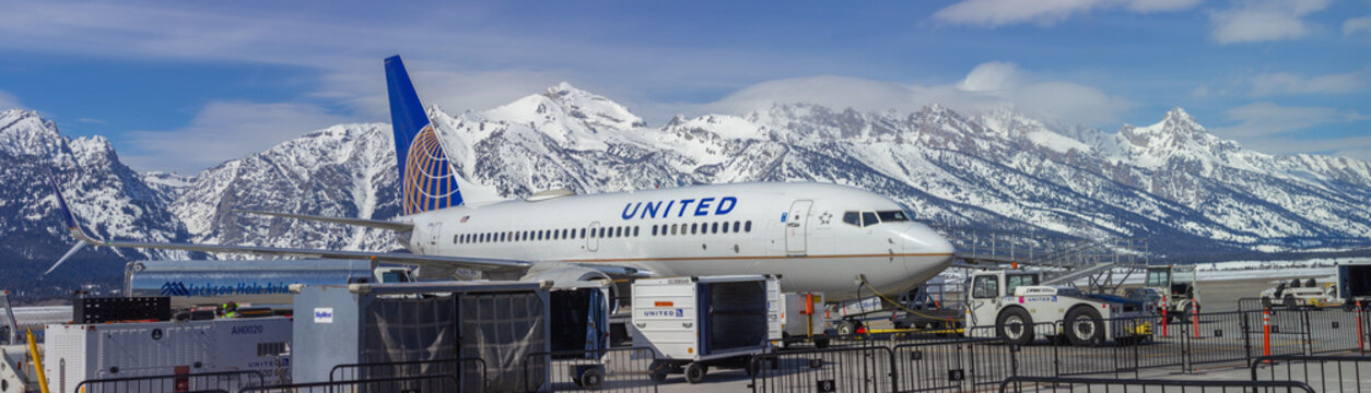 Jackson Hole Airport with United Airline plane on tarmac in front of Snow-Capped Mountains