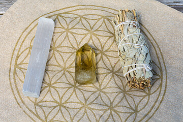 A top view image of a citrine crystal tower with selenite wand and white sage smudge stick. 